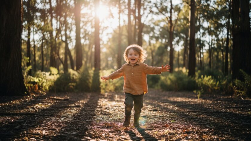 A heartwarming, 'epic moment' style photograph of a child laughing joyfully amidst the natural bushland of Belgrave South, sunlight dappling through gum trees, showcasing authentic kids photography in Belgrave South.
