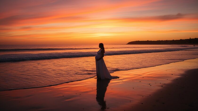 Epic Capel Sound Maternity Photography Beachfront Portraits featuring a glowing expectant mother at sunset, standing gracefully by the gentle waves with the stunning coastline in the background.