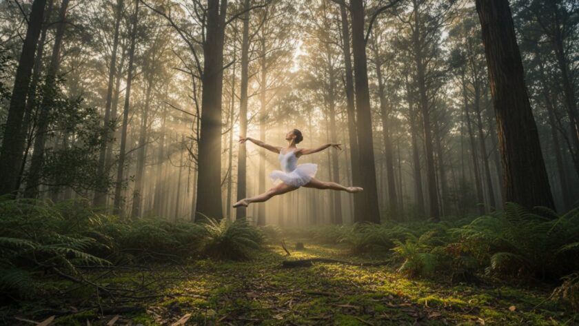 A professional dancer mid-air, frozen in an elegant leap, against the misty, lush green backdrop of Sherbrooke Forest at dawn, showcasing a breathtaking moment of Capturing Dynamic Dance Photography Sherbrooke Victoria.