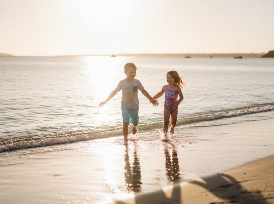Epic moment capturing playful kids photography Rye foreshore: two children laughing and splashing joyfully at sunset on the Rye beach.