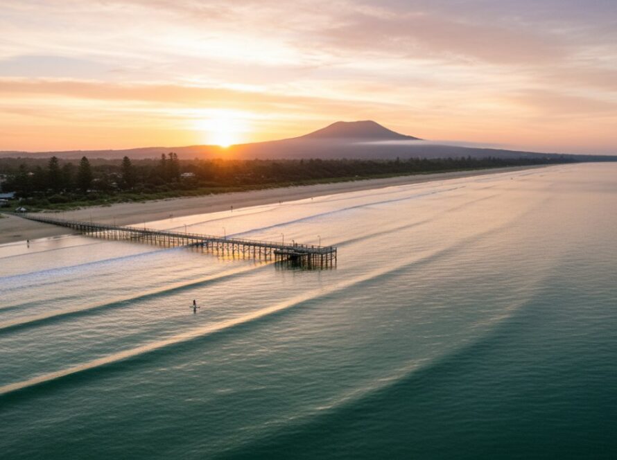 An epic moment captured by drone photography, showcasing the vibrant turquoise waters and golden sands of Dromana Foreshore at sunrise, with the iconic Dromana Pier stretching into the serene Port Phillip Bay, perfectly embodying Dromana Foreshore Drone Photography Capturing Coastal Beauty.