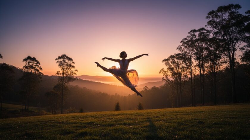 A powerful, high-energy image of a contemporary dancer mid-air, silhouetted against a dramatic sunset over the Dandenong Ranges near Selby, showcasing expert Selby dance photography capturing artistic energy.