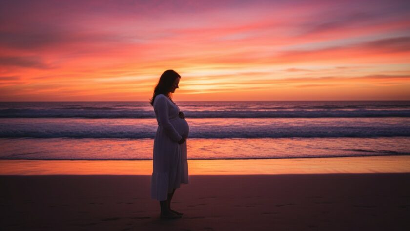 A glowing expectant mother stands silhouetted against a dramatic sunset on Somers beach, Victoria, during her Somers beach maternity photoshoot Victoria, capturing an epic, ethereal moment with the ocean waves gently lapping at her feet and the sky painted in fiery oranges and purples.
