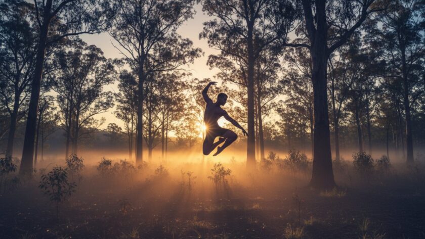 A dynamic shot of a dancer mid-leap against a misty, sun-drenched Upwey forest backdrop, showcasing Upwey dance photography capturing movement with incredible power and grace.