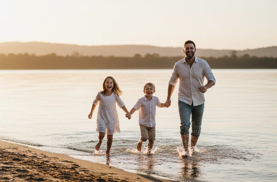 An intimate, authentic candid photography Colac moment of a family laughing genuinely together by Lake Colac at sunset, with warm golden light, showcasing their real connection.
