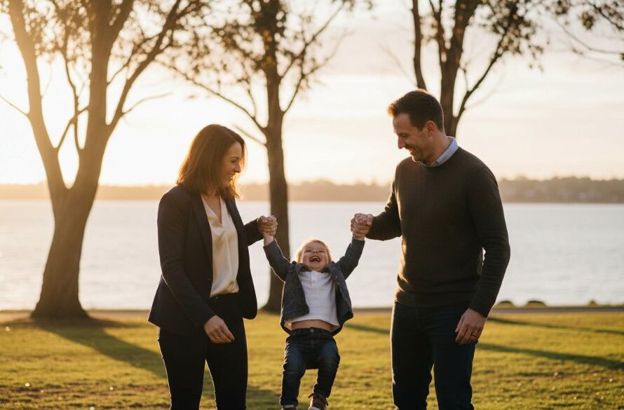 A heartwarming authentic candid photography family stories Drumcondra moment, capturing genuine laughter as parents swing their child against the backdrop of a sun-drenched Rippleside Park, evoking pure joy and connection.