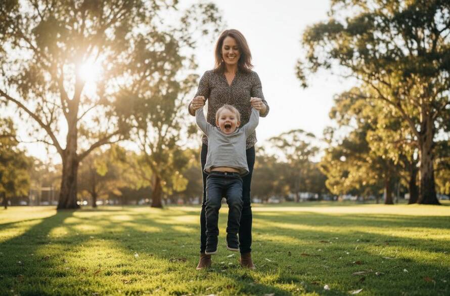An authentic candid photography Murrumbeena family moment, capturing a child's joyful laugh as they are gently swung by their parents in a sun-dappled park, with Murrumbeena's lush greenery in the background, professional colour grading.