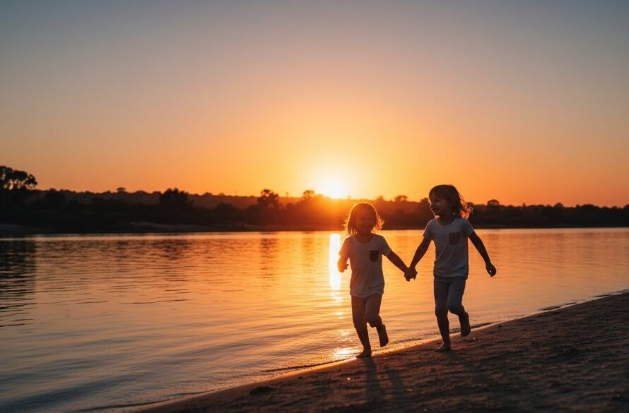 An authentic kids photography Geelong West family moments capture: two joyful children running hand-in-hand through golden hour light at Rippleside Park, their laughter echoing, professionally photographed with dramatic backlighting and vibrant colours.