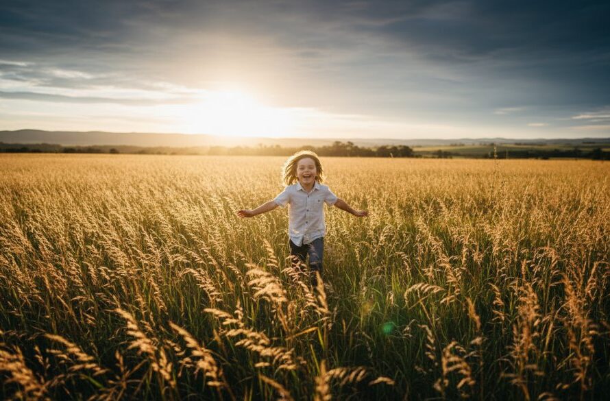 A professional, cinematic photograph capturing Bacchus Marsh Kids Photography Outdoor Adventures, showing a child joyfully running through a sun-drenched field near the Lerderderg Gorge, golden hour light, dramatic lighting, genuine laughter, dynamic composition.