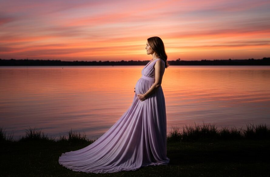 A glowing expectant mother, silhouetted against the dramatic sunset over Lake Wendouree in Ballarat Central, gently cradling her baby bump, encapsulating Ballarat Central maternity photoshoot timeless memories.