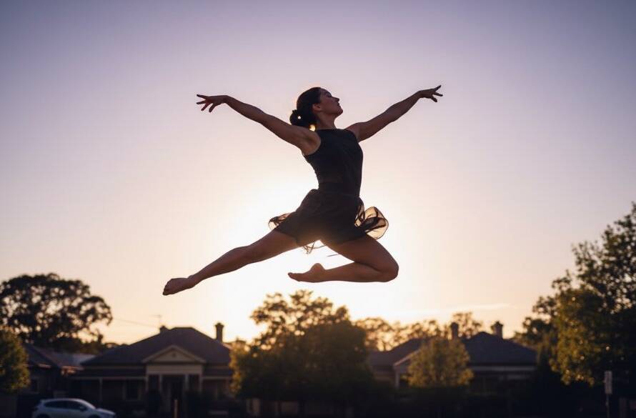 Dynamic, low-angle Balwyn dance photography capturing movement and emotion, featuring a female ballet dancer mid-air in an epic, powerful leap against the golden hour light near Balwyn Park, showcasing strength and grace.