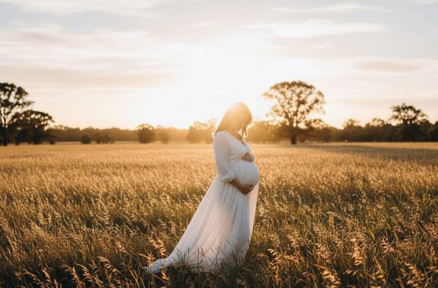 A glowing pregnant woman in a flowing gown, silhouetted against a golden sunset in a lush Bentleigh East park, during her bentleigh east outdoor maternity photography session, embodying serene anticipation.