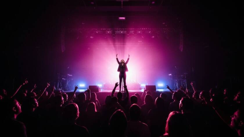 A dynamic, wide-angle shot capturing the essence of Black Rock Victoria live music photography, featuring a lead singer with arms outstretched, silhouetted against vibrant stage lights, with a cheering crowd in the foreground creating an epic moment of connection.