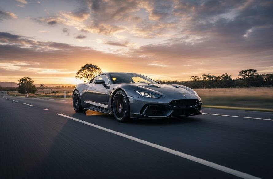 A high-angle, cinematic shot of a gleaming midnight blue luxury sports car speeding along a winding, tree-lined road at sunset in Burnside Heights, Melbourne, perfectly showcasing Burnside Heights luxury car photography Melbourne, with dramatic light catching its contours and motion blur in the background, conveying power and elegance.
