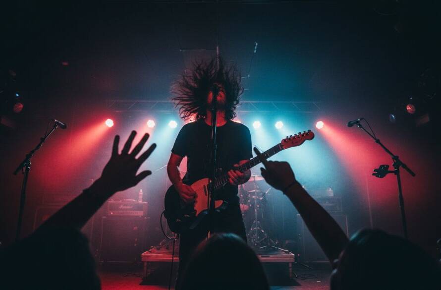 Dynamic wide-angle shot showcasing a lead singer mid-scream with spotlight on stage at a vibrant Camberwell live music event, expertly captured by Camberwell Live Music Photography Expertise, depicting the raw energy and crowd excitement with dramatic lighting.
