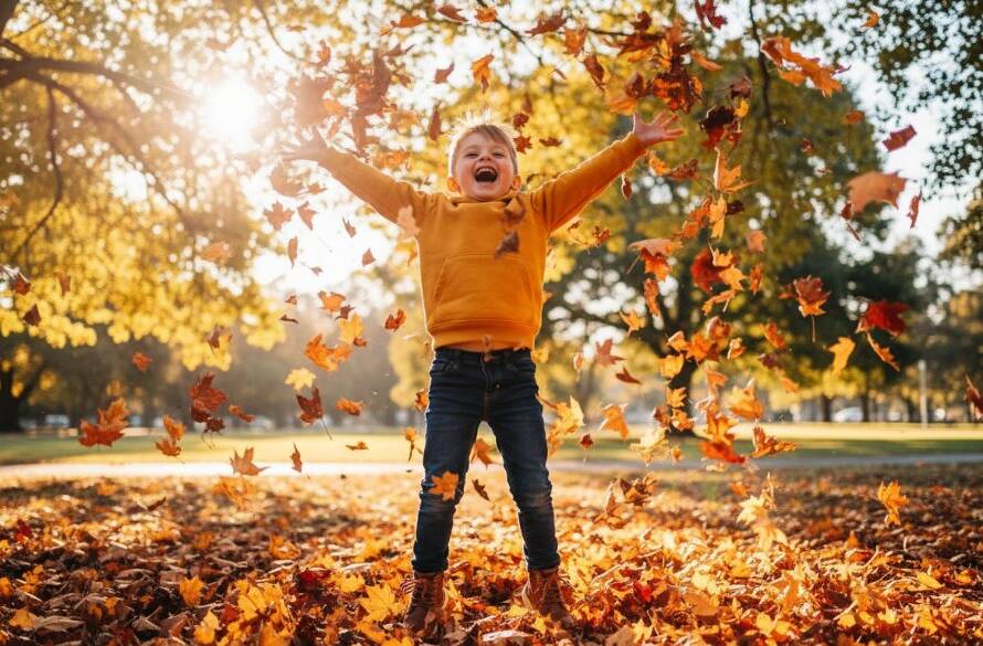 A joyous, candid kids photography Bayswater Victoria moment: a child mid-laugh, playing with colourful autumn leaves in a sun-drenched park, perfectly captured with dramatic lighting.