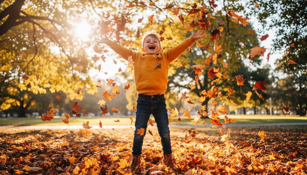 A joyous, candid kids photography Bayswater Victoria moment: a child mid-laugh, playing with colourful autumn leaves in a sun-drenched park, perfectly captured with dramatic lighting.