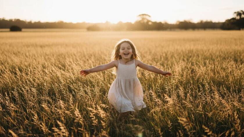A vibrant, emotionally rich photograph capturing candid kids photography Deer Park family moments, showing a child laughing joyfully amidst the golden hour light in a Deer Park park, with parents smiling in the soft background, creating a timeless, epic memory.