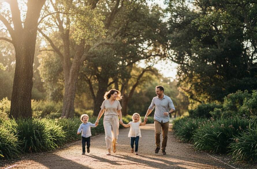 A joyful family of four, parents laughing as their children run through golden hour light in a beautiful Armadale park, perfectly capturing authentic Armadale family photography moments with warm, cinematic tones.