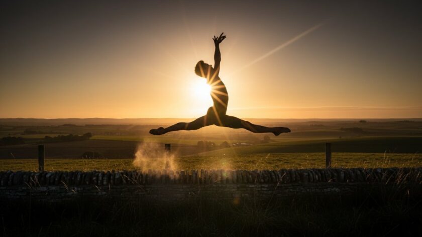 A male dancer captured mid-leap against a dramatic sunset sky over Miners Rest, Victoria, embodying the essence of capturing dynamic dance photography Miners Rest Victoria, with powerful athletic grace and artistic expression.