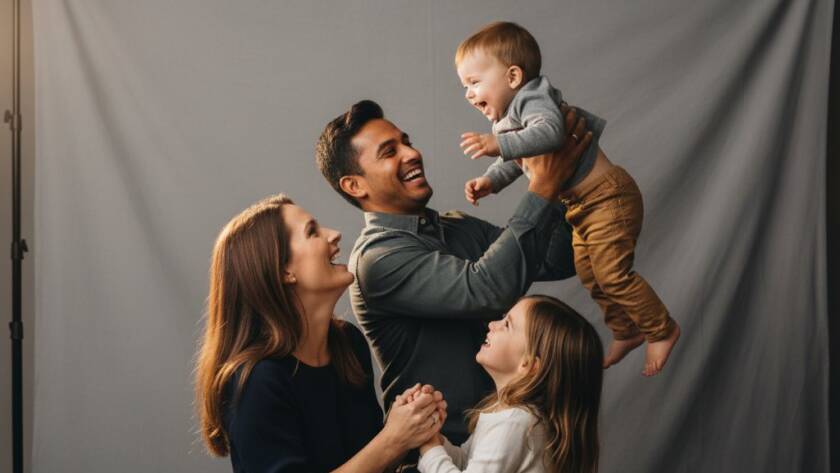 An emotionally resonant, epic moment captured in a professional studio, showcasing a family joyfully embracing during a 'Capturing family milestones studio photography Sunshine North' session, with dramatic, soft lighting illuminating their genuine expressions, celebrating a significant life event.