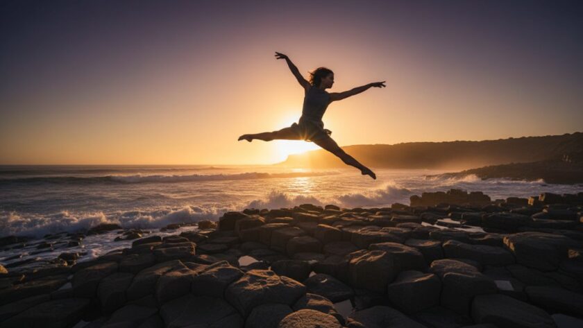 A professional photograph capturing graceful dance Warrnambool coastline: a dancer in mid-leap, silhouetted against a dramatic sunset over the Southern Ocean, evoking an epic moment of artistry and power.
