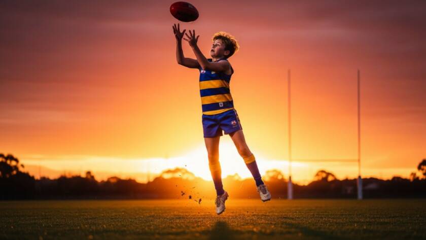 A dramatic, low-angle shot of a young soccer player in mid-air, scoring a goal during a game in Endeavour Hills, showcasing the triumph of capturing junior sports triumphs Endeavour Hills with dynamic lighting and blurred background.