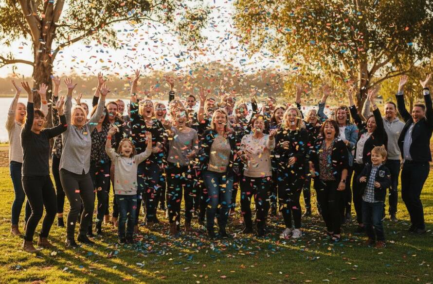 An epic moment of pure elation captured by Caroline Springs event photography capturing genuine joy, showing guests cheering with confetti falling at a vibrant outdoor celebration near the lake in Caroline Springs, Victoria, with dramatic golden hour lighting highlighting their expressions.