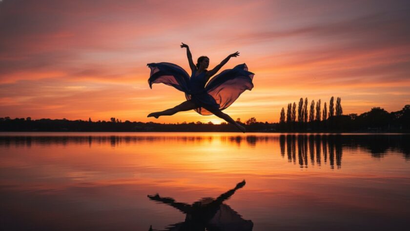 A powerful contemporary dance photography Lake Wendouree foreshore image capturing a female dancer mid-air in a dramatic leap at sunset, with the iconic lake and trees silhouetted in the background, showcasing incredible grace and athletic power.