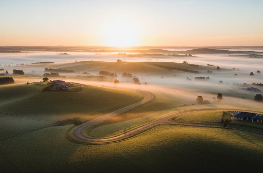 An epic aerial shot capturing the stunning sunset over the rolling hills of Delacombe, Victoria, showcasing the captivating views of the rural landscape and distant town lights, taken by Delacombe Victoria drone photography captivating views experts.
