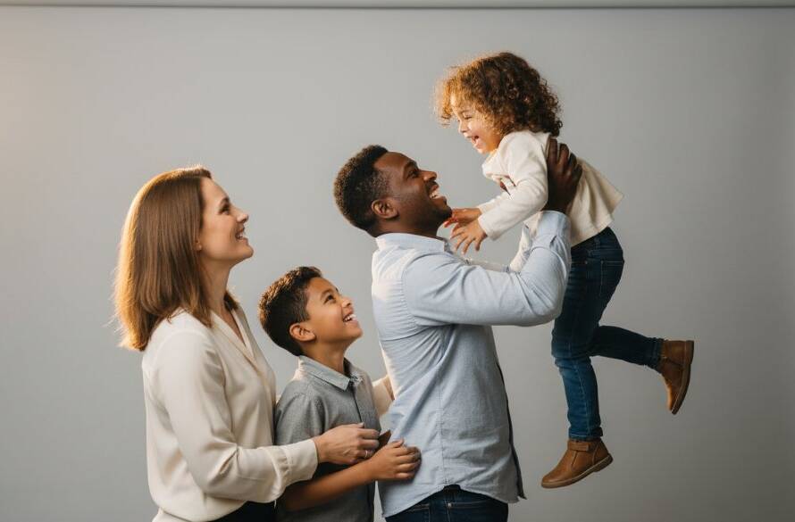 A heartwarming, professionally captured studio photograph of a multiracial family embracing joyfully, with soft, dramatic rim lighting, showcasing their genuine connection, epitomising Dingley Village Studio Photography for Timeless Family Portraits.