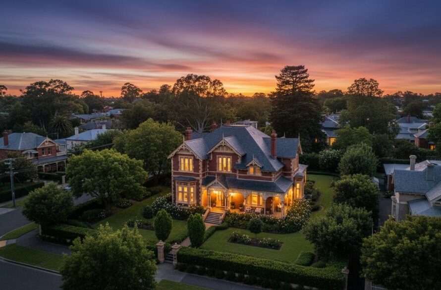 A breathtaking aerial view showcasing a beautifully manicured heritage home in Drumcondra, Victoria, bathed in golden hour light, captured by expert Drumcondra Victoria Professional Real Estate Photography. The photograph highlights the property's grandeur and its proximity to lush, tree-lined streets, creating an inviting and luxurious visual.
