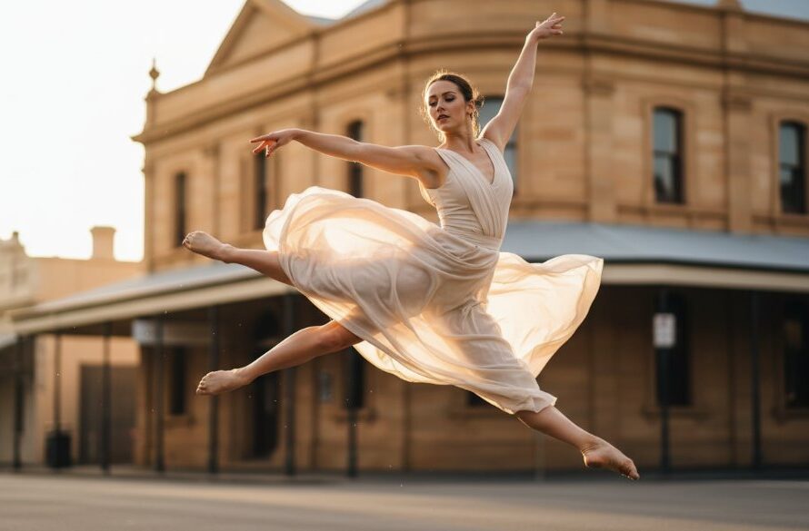 A powerful dynamic Castlemaine dance photography capture showing a dancer frozen mid-air in an elegant leap against the dramatic backdrop of historic Castlemaine architecture at dusk, illuminated by professional studio lighting.