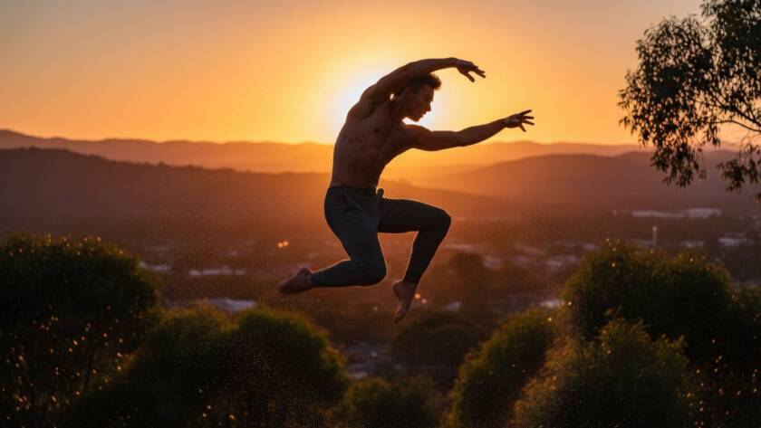 A male contemporary dancer in a powerful, soaring leap against a vibrant Heatherdale sunset, expertly showcasing dynamic dance photography Heatherdale Victoria with dramatic rim lighting and perfect form.