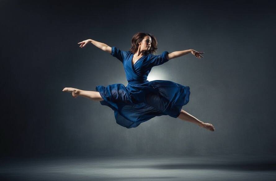 A dancer in mid-air, performing an elegant leap against a dramatic studio backdrop, bathed in theatrical lighting, showcasing dynamic dance photography Langwarrin studio sessions at their peak.