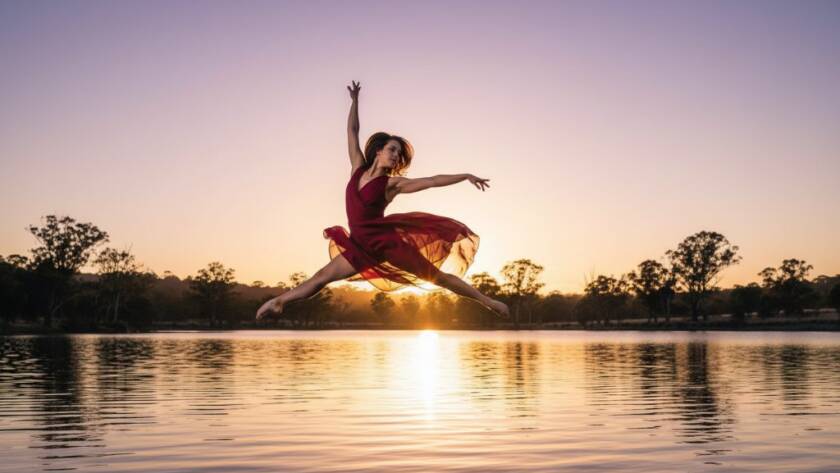A professional photograph showcasing a dancer in an epic moment of dynamic dance photography Lysterfield Lake, mid-leap against a dramatic sunset, capturing raw power and grace with stunning light.