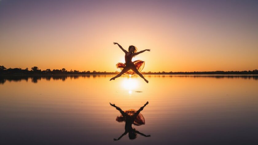A professional photograph capturing a breathtaking, dynamic dance pose by Lake Mulwala at sunset, showcasing the fluid motion of a dancer against the serene backdrop, for Dynamic Dance Photography Yarrawonga Lake Mulwala.