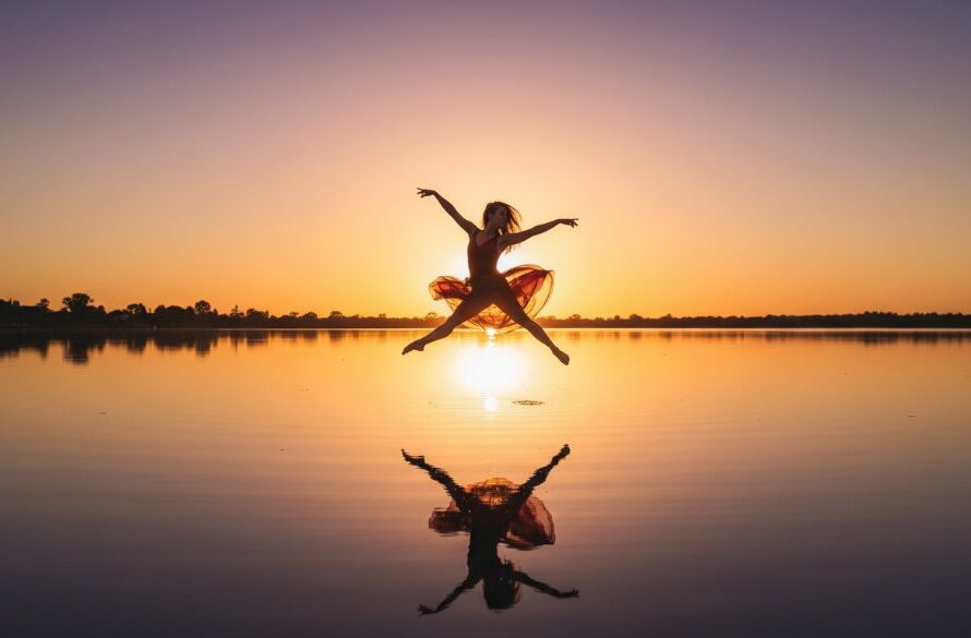 A professional photograph capturing a breathtaking, dynamic dance pose by Lake Mulwala at sunset, showcasing the fluid motion of a dancer against the serene backdrop, for Dynamic Dance Photography Yarrawonga Lake Mulwala.