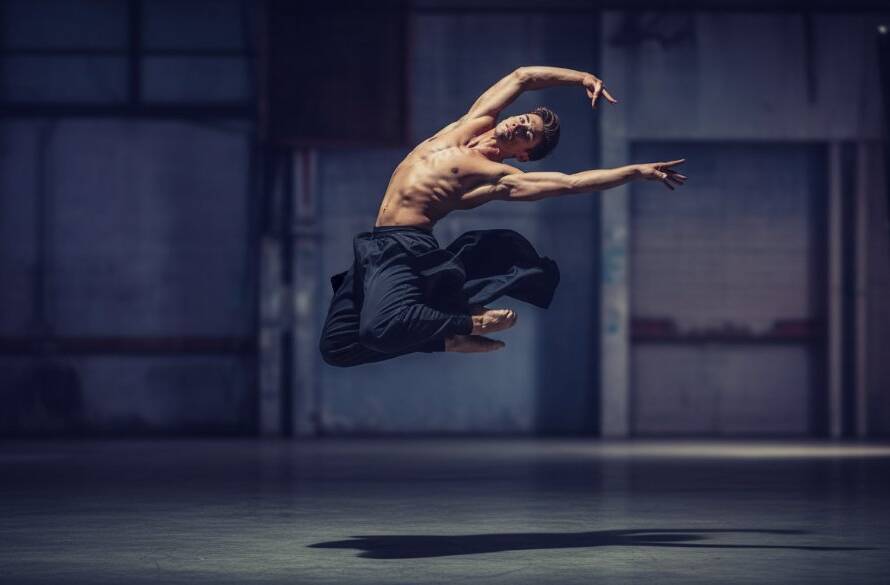 An epic moment captured: a dancer in mid-air performing a powerful leap against a soft-focus background, showcasing dynamic Ferntree Gully dance photography portraits with dramatic lighting and professional colour grading.