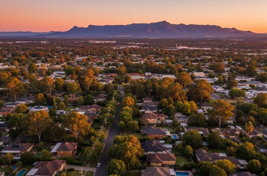 An epic moment captured by elevated aerial photography Ringwood North, showcasing a vibrant sunset over the leafy suburbs with the distant Dandenong Ranges, revealing a breathtaking, professionally colour-graded panoramic view.