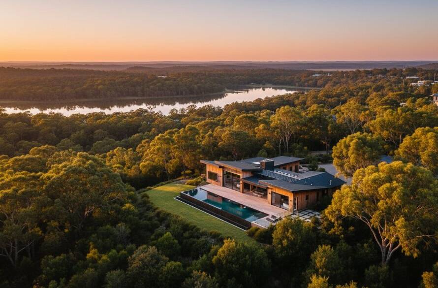 An aerial wide shot capturing the golden hour glow over a modern luxury home in Lysterfield, Victoria, with Lysterfield Lake in the background, perfectly demonstrating elevating Lysterfield homes with professional real estate photography for an epic buyer experience.