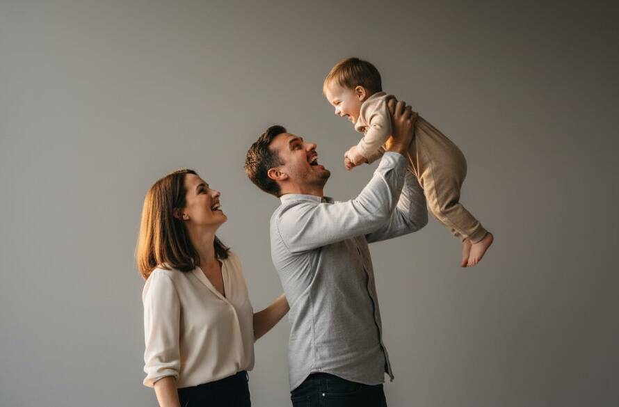 A stunning, color-graded professional photograph showcasing an 'epic moment' of a radiant family in a modern studio setting in Keilor Park, captured with elite studio photography techniques. The parents are laughing joyfully while holding their child, bathed in dramatic, soft light, creating a timeless, emotionally rich portrait.
