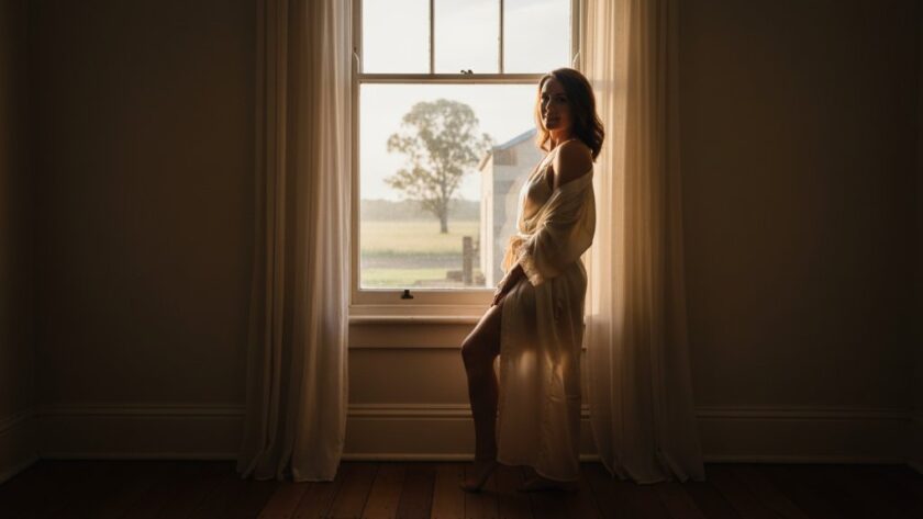 A stunning, soft-focus portrait of a woman bathed in dramatic natural light, evoking confidence and grace during an Empowering Boudoir Photography Kilmore Victoria session, capturing an epic moment of self-discovery.