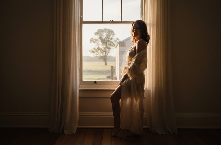 A stunning, soft-focus portrait of a woman bathed in dramatic natural light, evoking confidence and grace during an Empowering Boudoir Photography Kilmore Victoria session, capturing an epic moment of self-discovery.