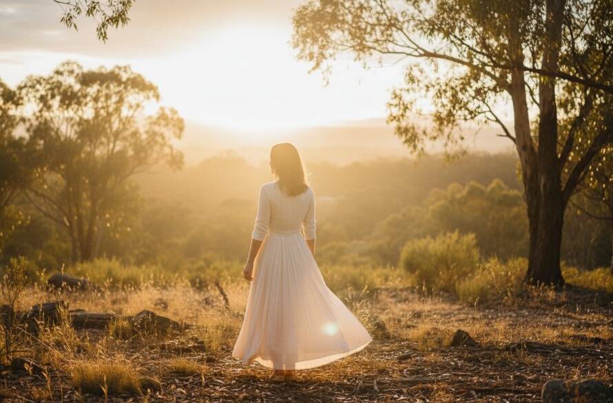 A dramatic fine art portrait from enchanting fine art photography sessions in Park Orchards, featuring a subject silhouetted against a golden hour sky over a rustic landscape, bathed in warm, ethereal light.