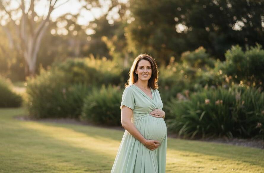 A pregnant woman in a flowing gown stands silhouetted against a golden Heatherdale sunset, embodying the enchanting Heatherdale maternity photography sessions, with soft light highlighting her baby bump, capturing an epic, serene moment.