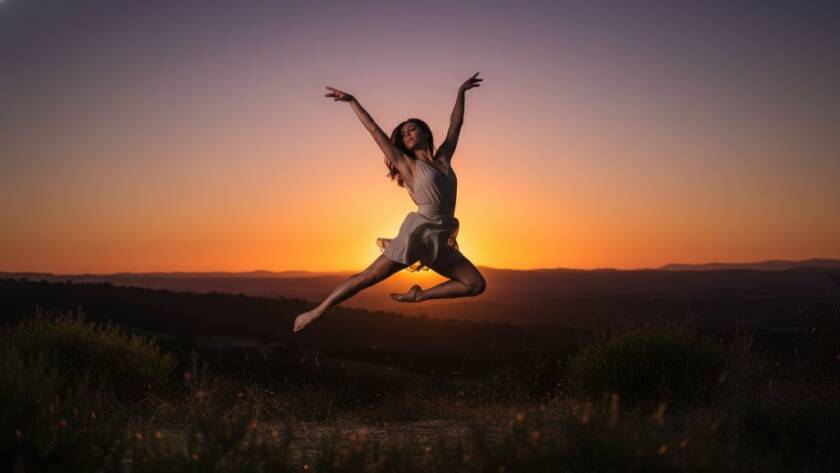 Dynamic shot of a contemporary dancer mid-leap, silhouetted against a golden sunset over the Dandenongs from Endeavour Hills, showcasing professional Endeavour Hills dance photography capturing epic moments.