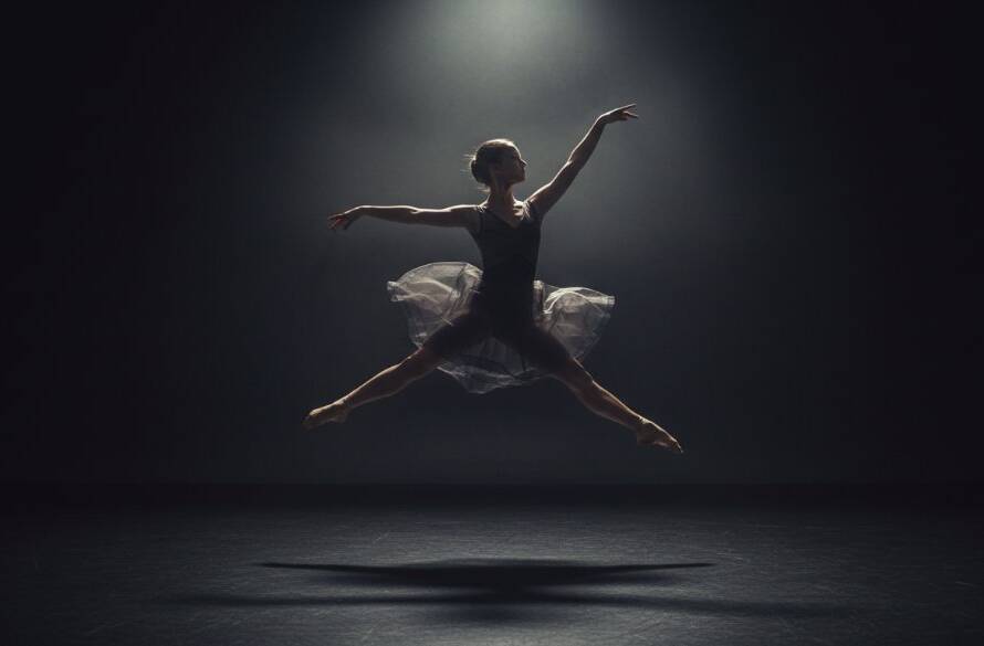 A dramatically lit black and white portrait of a mother holding her newborn baby in a minimalist studio setting in Officer, Victoria, showcasing the deep emotional bond. This image exemplifies exceptional studio photography Officer Victoria, capturing a timeless, intimate moment with artistic precision.