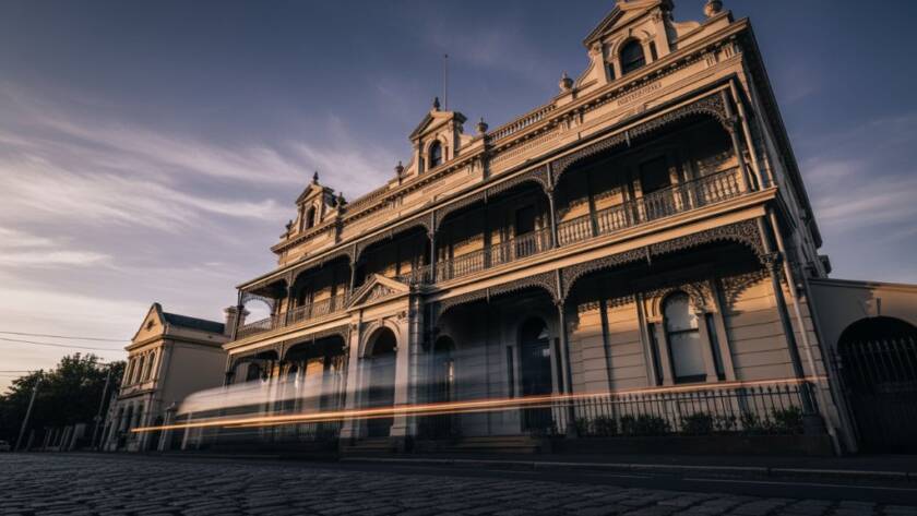 A dramatic long-exposure shot of a grand heritage building in Caulfield at twilight, showcasing intricate Victorian-era details under a rich, moody sky, expertly captured for expert Caulfield architecture photography Melbourne heritage.