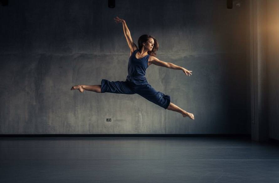 A dynamic, epic moment captured in Expressive Dance Photography Blackburn South Studio, featuring a dancer mid-leap, silhouetted against dramatic lighting, showcasing powerful movement and grace.